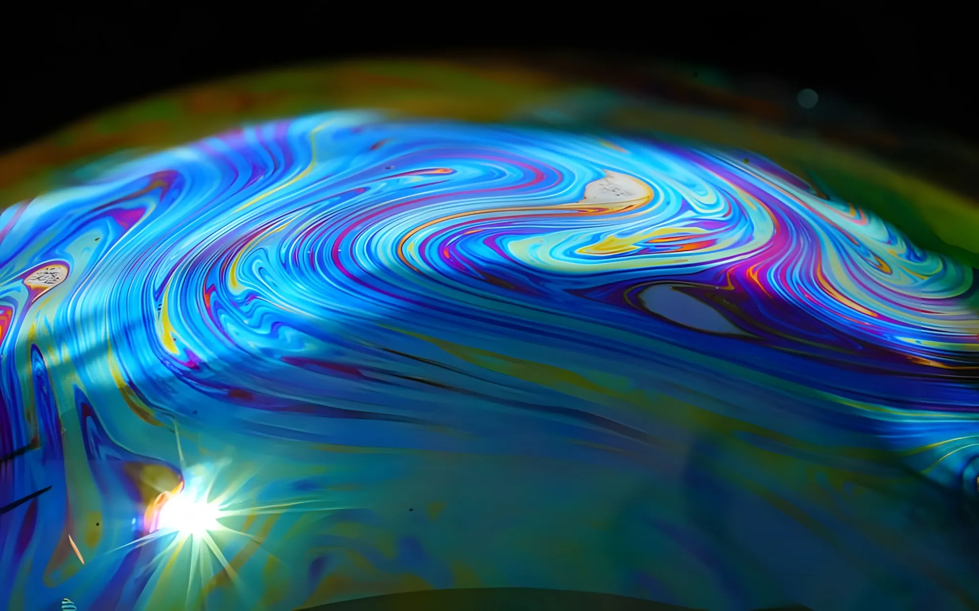 Dettaglio ravvicinato di una bolla di sapone con vortici colorati blu, viola e giallo