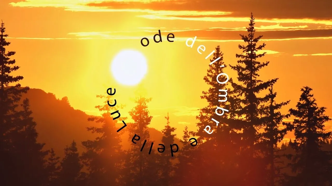 Sole bianco in un cielo arancione tra sagome di abeti, con il titolo Ode dell'Ombra e della Luce scritto ad arco