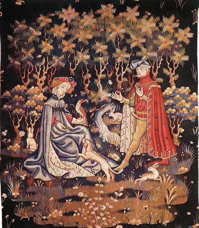 Arazzo medievale con un gentiluomo in rosso che offre un cuore a una dama seduta nel bosco, tra cani e conigli