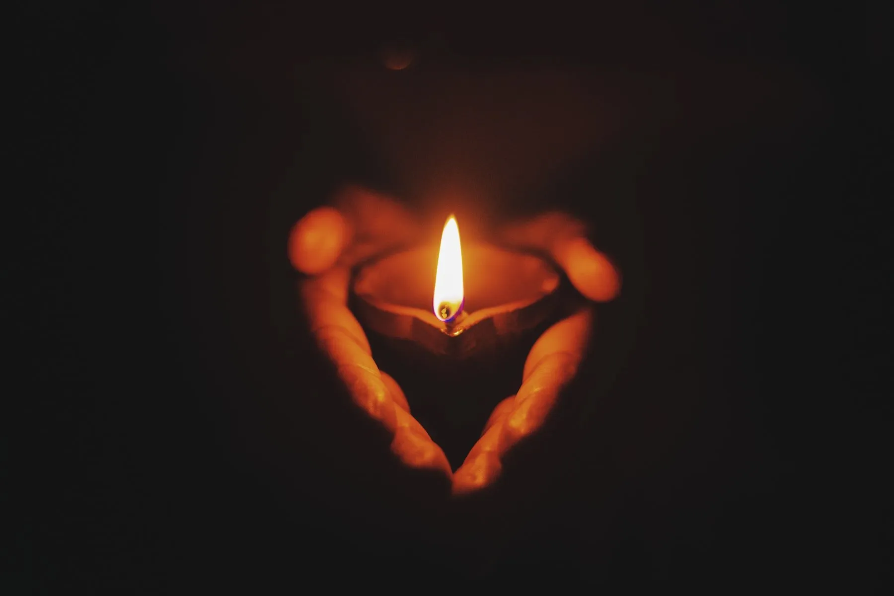 person holding lighted oil lamp
